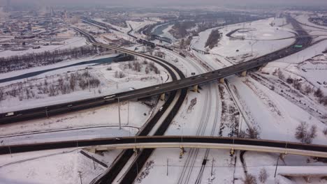 Reveladora-Toma-Aérea-De-Una-Carretera-Y-Un-Ferrocarril-Invernales-En-Canadá.