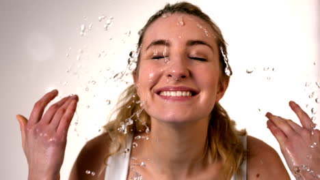 Woman-splashing-her-face-on-white-background