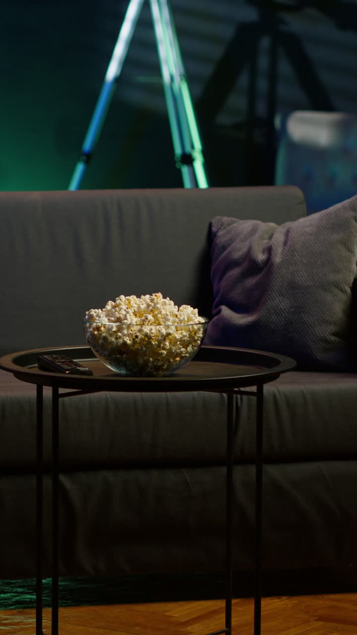 Vertical video Popcorn on coffee table in home room with dimmed lighting