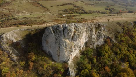 Aerial-panning-high-angle-shot-of-big-high-rock-on-the-edge-of-a-mountain-4