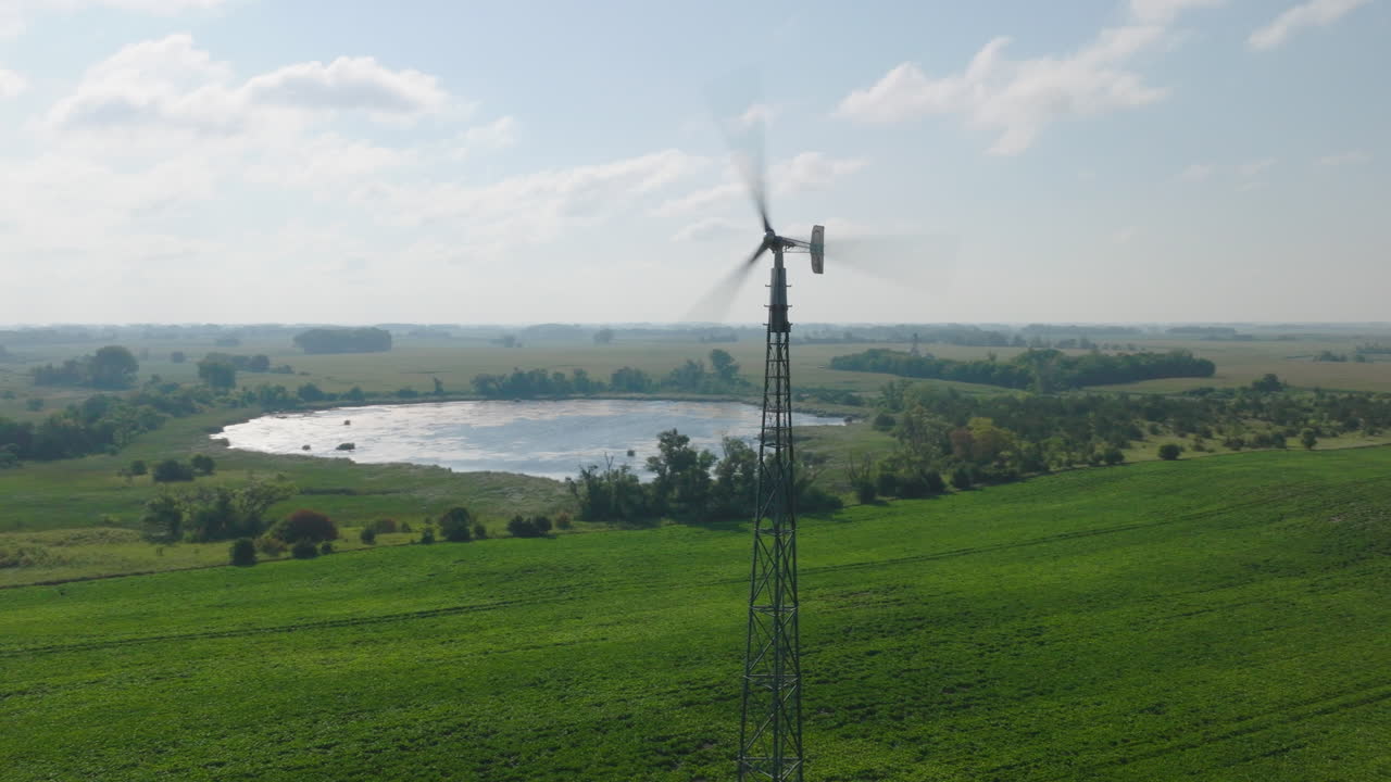 Riprese aeree di una piccola turbina eolica agricola che genera elettricità in campagna.