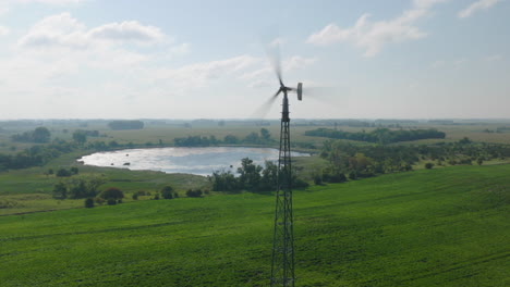 aerial footage of a small farm wind turbine generating electricity in rural countryside