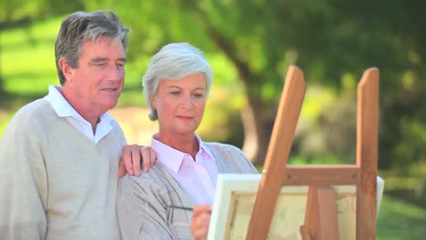Mature-couple-looking-at-a-painting-