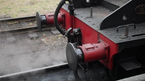 steam engine train on the tracks with bumpers in a cloud of smoke