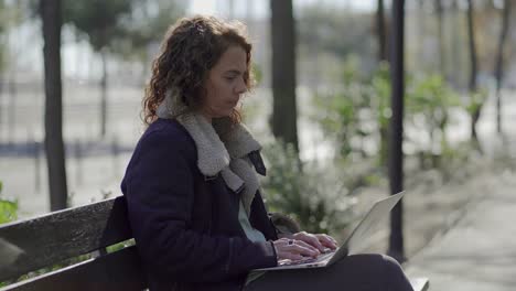 Concentrated-middle-aged-woman-typing-on-laptop