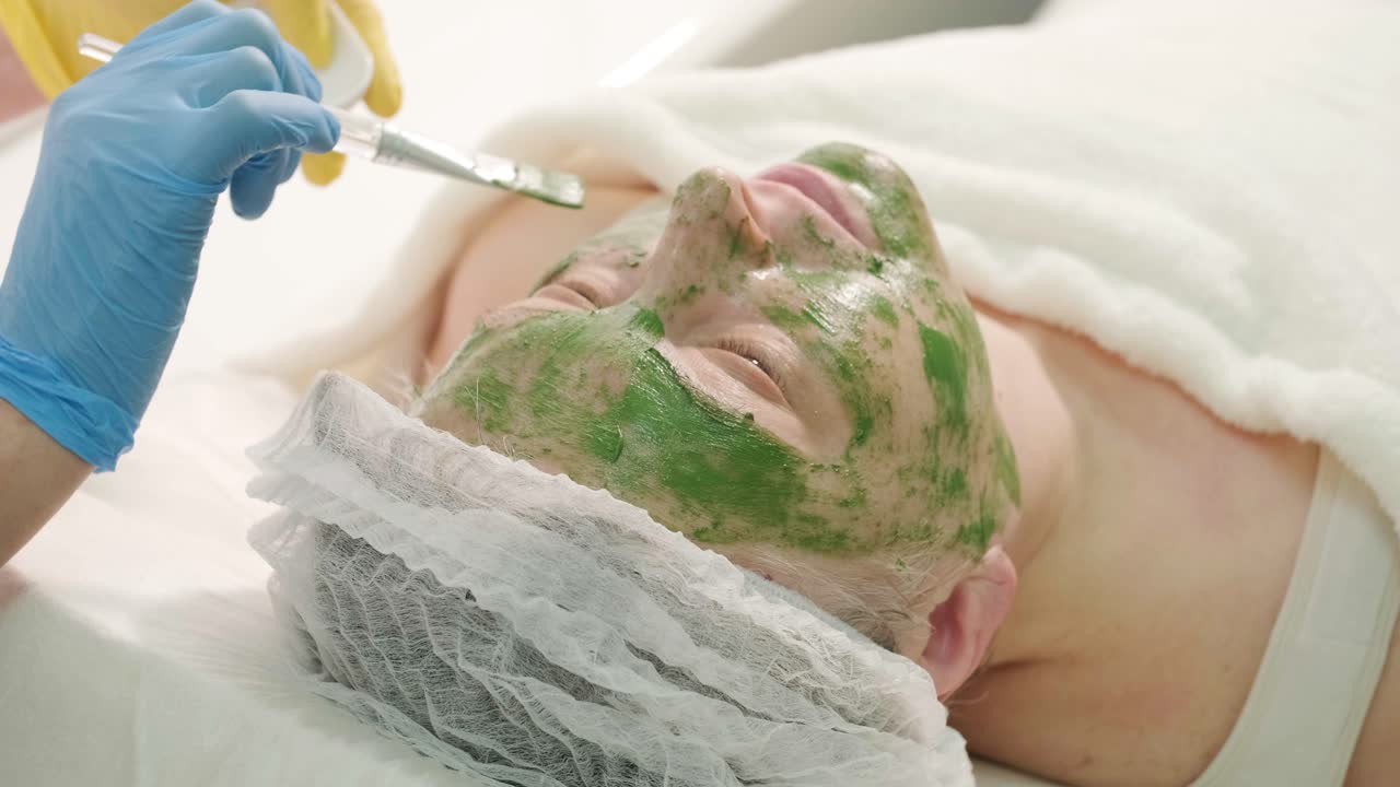 현대 화장품 클리닉에서 전문적인 얼굴 관리 절차. 얼굴 마스크 적용