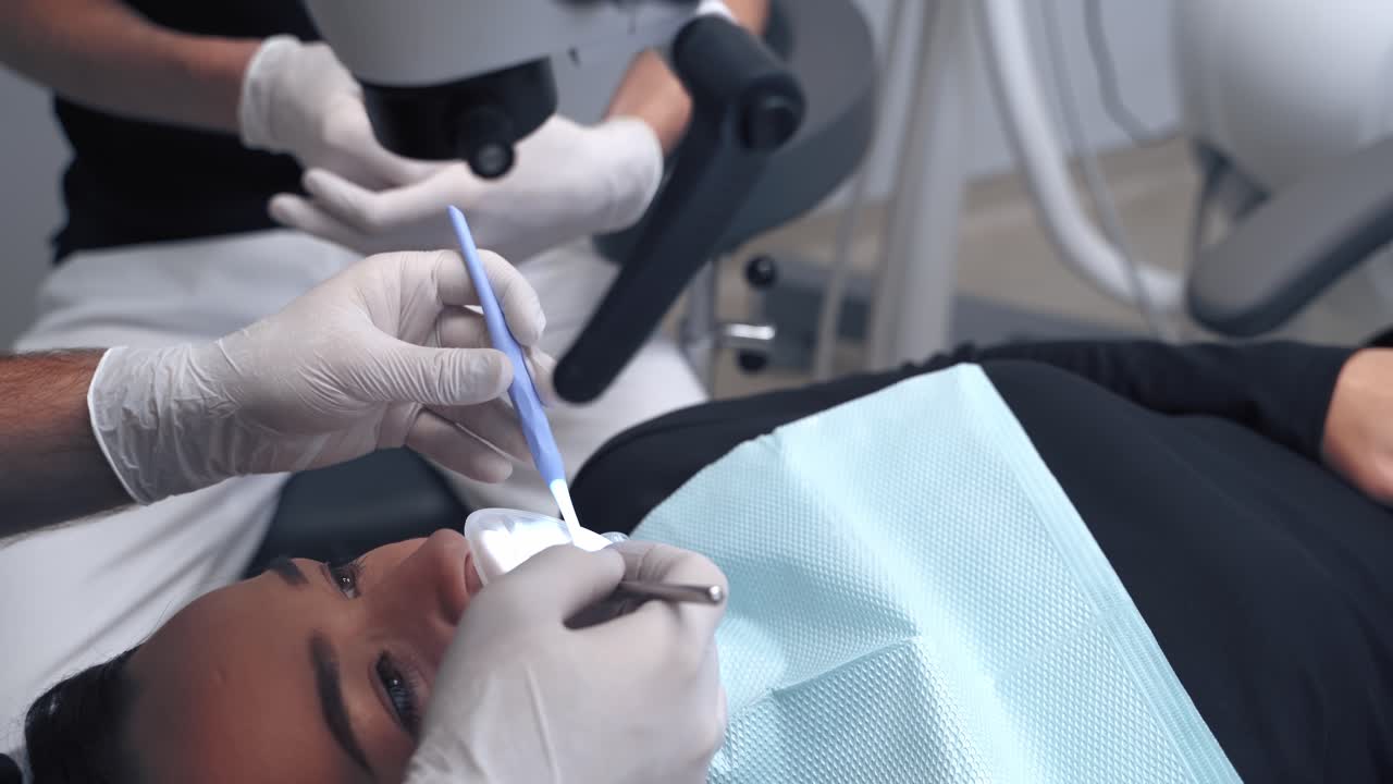 Young woman in stomatology clinic. Female in stomatology while stomatologist holding dental instruments
