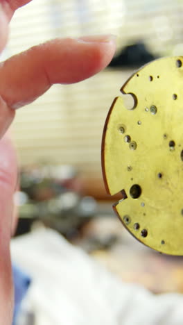 horologist holding a clock part