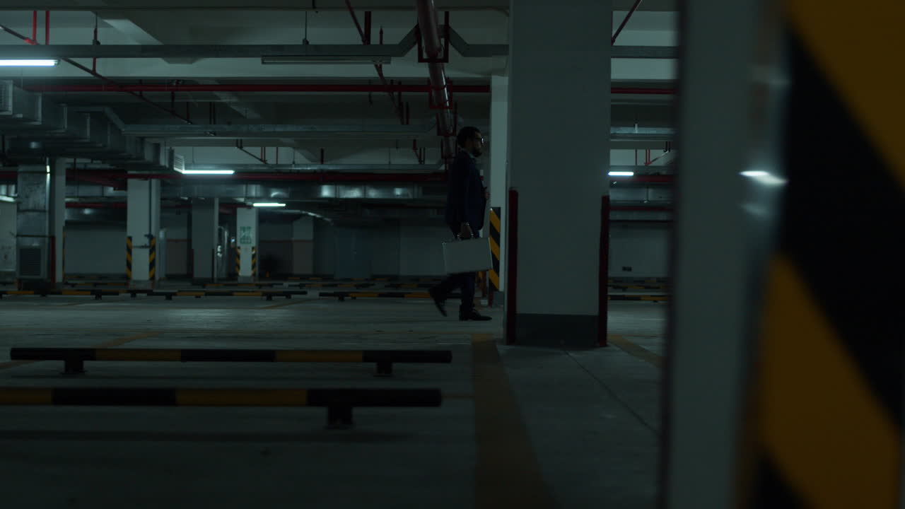 Businessman Walking in Empty Night Parking Garage