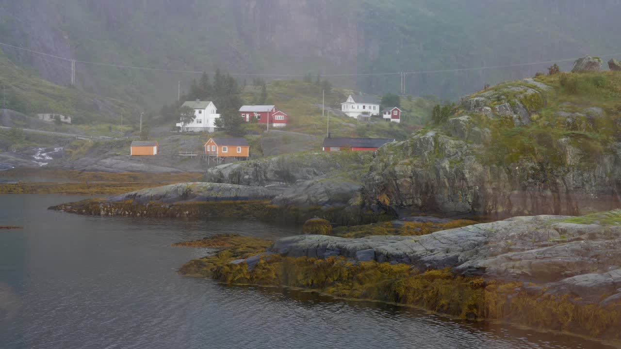 casas en una colina rocosa en las islas lofoten de noruega a través de vidrio