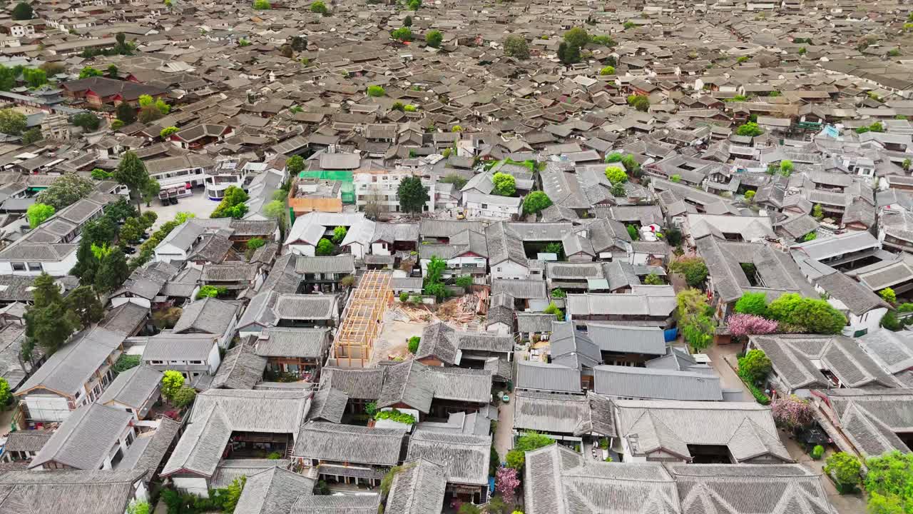 Aerial drone fly Traditional Chinese Architecture in Lijiang Old Town, Cultural Landmark, revealing mountains, establisher