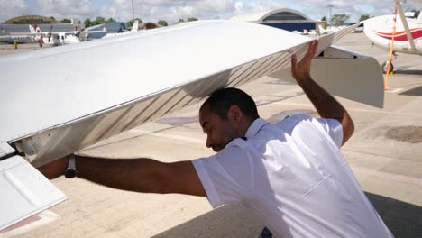 un piloto revisa el flap debajo del ala