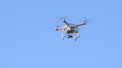 white quadcopter drone hovering and spinning in mid-air, close up