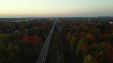 Vía-Delantera-De-Una-Sección-De-Ferrocarril-Bordeada-De-árboles-Que-Florecen-Colores-De-Otoño