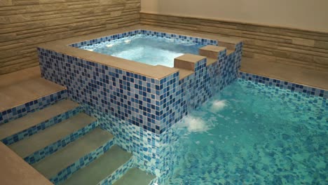 indoor jacuzzi with water flowing into swimming pool