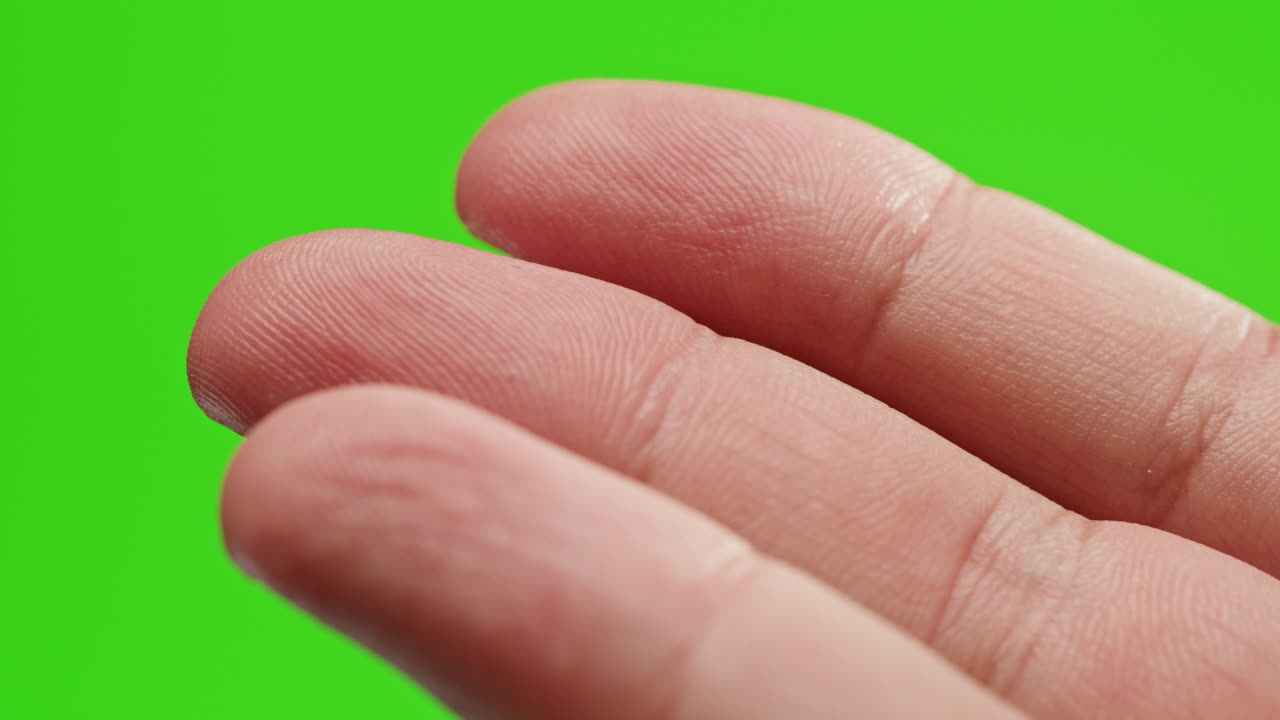 Close-up of two fingers on a green screen