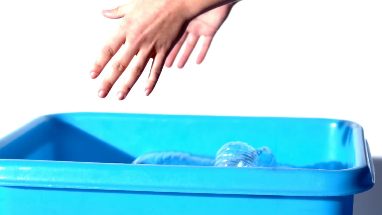 여성 손 이 쓰레기통 에 병 을 던지고 있다