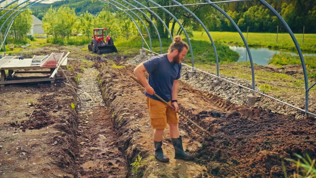 Construction of a pipe arch shaped greenhouse in rural Norway with greenhouse framework being assembled on a farm landscape - timelapse