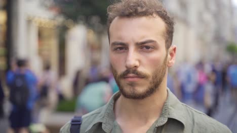 young man looking at camera in the city center.