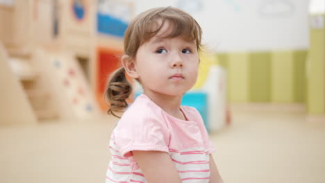 退屈な3歳の女の子 遊び室で木の棒で遊びながら 玩具のキシロフォンで ゆっくりと - 顔のクローズアップ