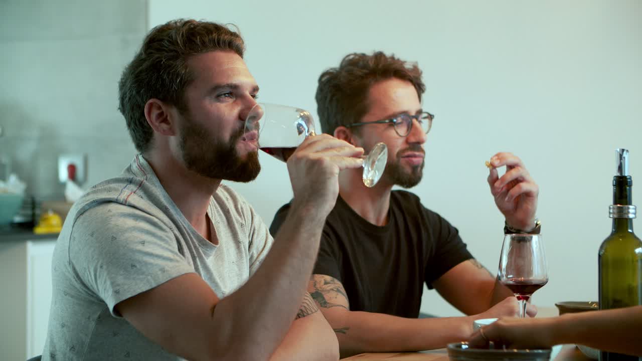 Handsome bearded man talking and drinking red wine