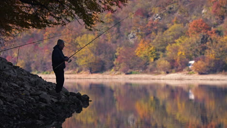 a fisherman enjoys a peaceful day of fishing on a beautiful autumn lake