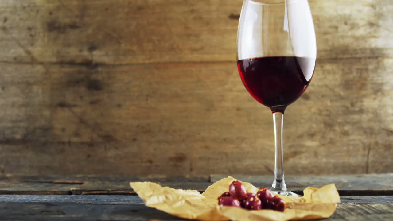 Bicchiere di vino rosso e tapas di olive rosse