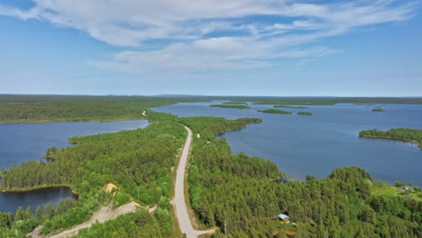 Aerial-view-of-a-road-in-middle-of-lakes-in-Vatsari-wilderness,-summer-in-Lapland