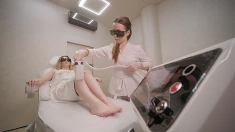 laser epilation and cosmetology in beauty salon. cosmetology, spa and hair removal concept. laser hair removal procedure of female legs. doctor in gloves.