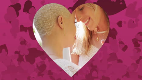 animación de corazones flotando sobre una pareja casada de mujeres diversas abrazándose