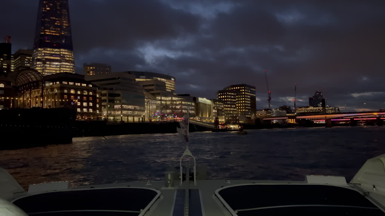 The flag of the United Kingdom waving on a boat moving on the Thames River in the evening in London, England