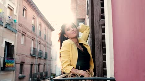 calm young woman standing on balcony in city