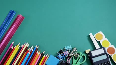 school supplies arranged on green background