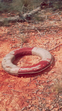 un salvavidas desgastado se sienta en un paisaje desértico seco y rojo