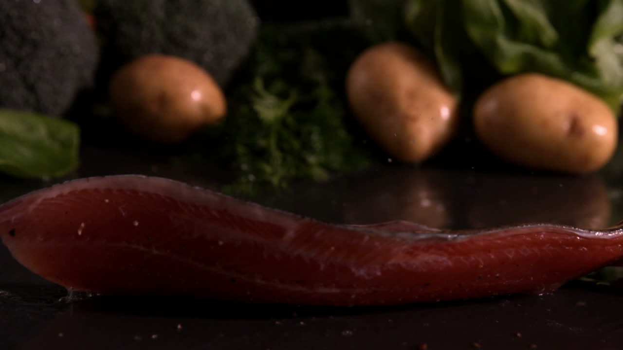 Trout fillet falling in front of vegetable selection