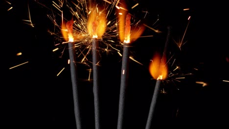 Bengal-fires,-New-Year-sparkler-candles,-sparkling-lights-burning-on-a-black-background,-slow-motion