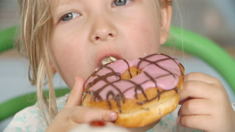 close up of girl eating iced donut