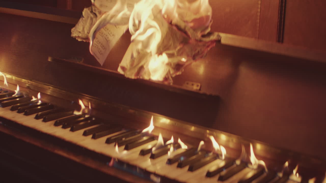 A burning vertical piano in slow motion