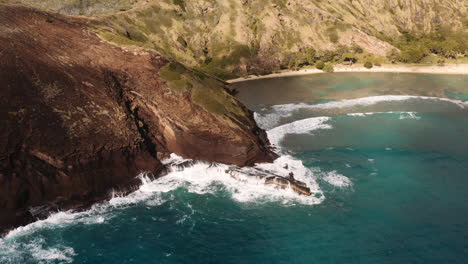 aerial drone shot of waves crashing against rocky coastline