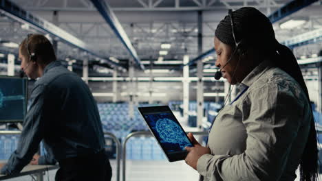 server room tech support employee using ai on tablet to guide clients