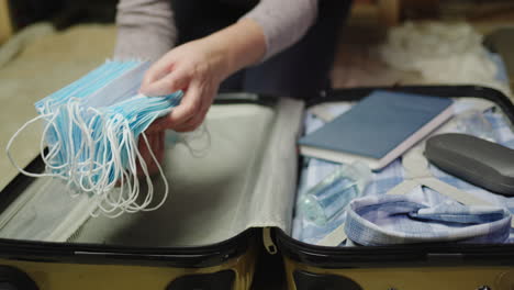 a woman packs clothes and face mask for a business trip 6