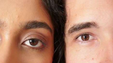 close-up of young couple's faces, one with eyes closed and one with eyes open, at home