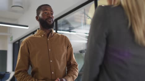 two diverse businesspeople discussing together and standing at table