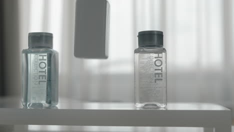 a closeup of three cosmetics bottles being put on a table