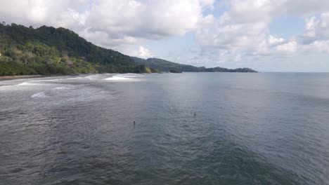 Luftaufnahme-Von-Zwei-Personen-Im-Ozean-In-Dominical-Beach-Costa-Rica,-Orbit-Wide-Shot