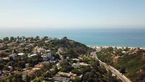 luxury american housing area on top of mountain with road leading to sandy beach of pacific ocean