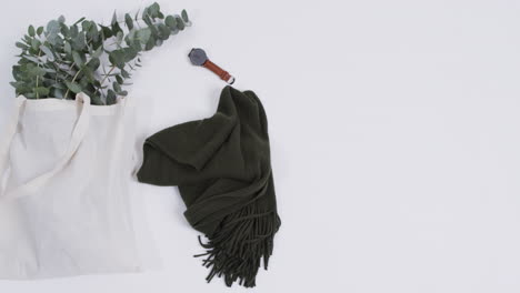 video de una bolsa de lona blanca con planta, bufanda, reloj, espacio de copia sobre un fondo blanco