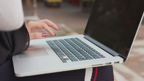 Woman-Sat-Outside-Inputting-Data-Onto-Her-Laptop,-In-Slow-Motion