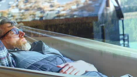 man lying on a hammock in a farm