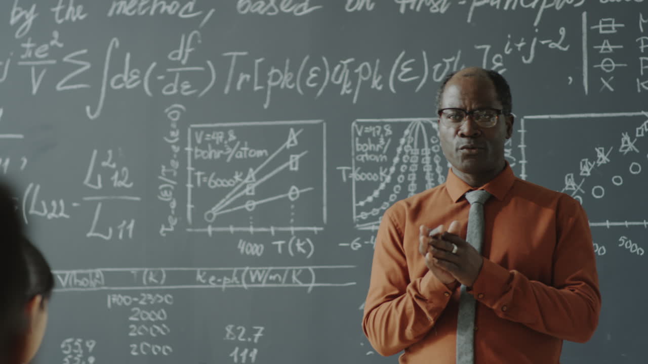 African American Professor Lecturing in Classroom with Blackboard of Equations